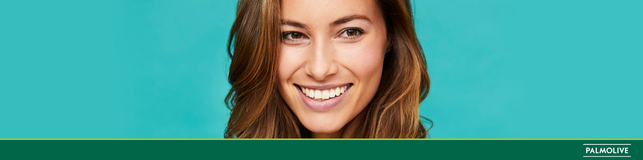 Mulher sorrindo de cabelo solto tratado colhendo os benefícios do óleo de argan para o cabelo