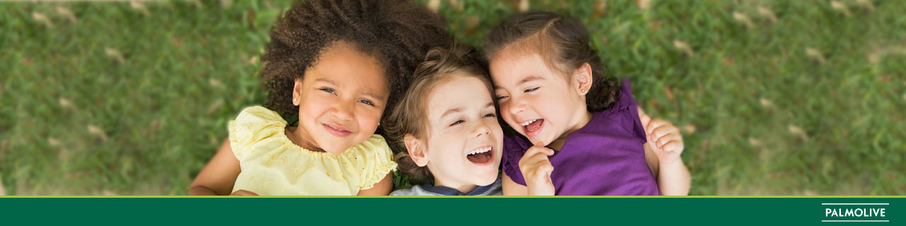 Crianças com cabelos infantis deitadas uma ao lado da outra, sorrindo e  brincando