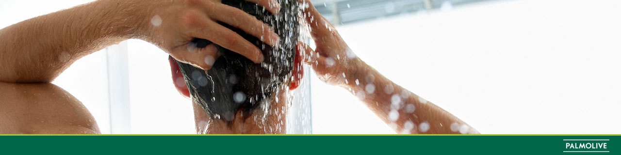 Homem lavando a cabeça com shampoo masculino