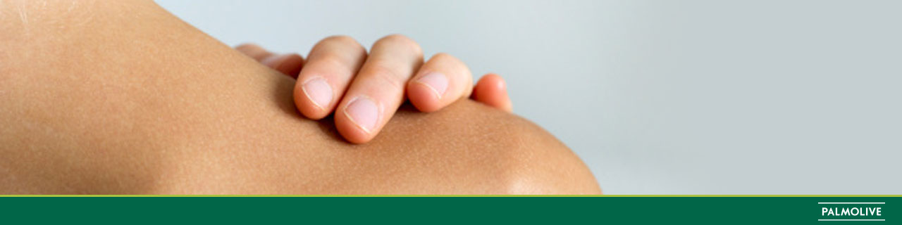 Mulher passando a mão no ombro e tomando banho com sabonete para pele seca