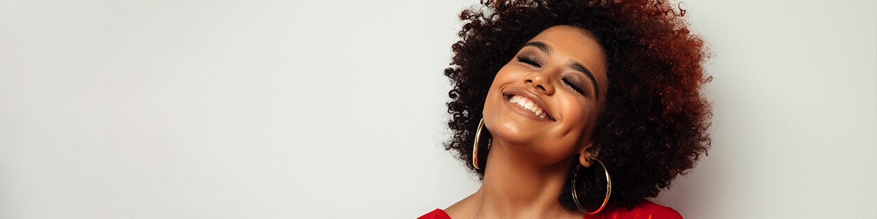 mulher negra com cabelo cacheado sorrindo