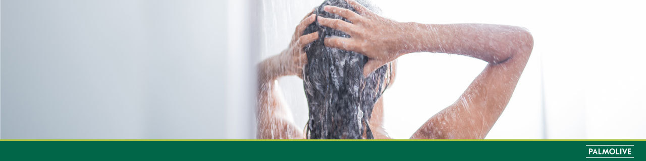 Mulher lavando a cabeça com shampoo para cabelo oleoso