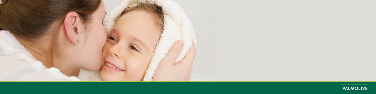 Mãe beijando seu bebê que acaba de lavar a cabeça com shampoo infantil