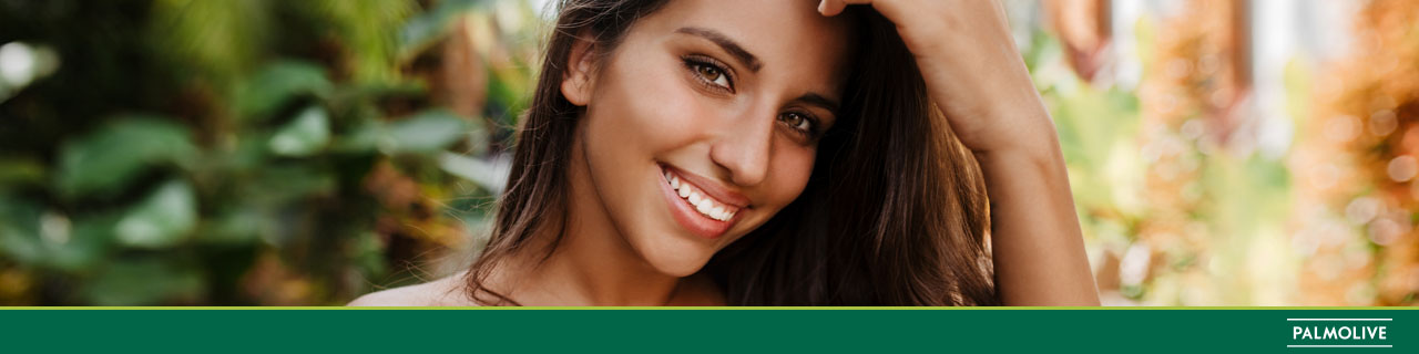 Mulher com o cabelo solto sorrindo e pensando em como fortalecer o cabelo