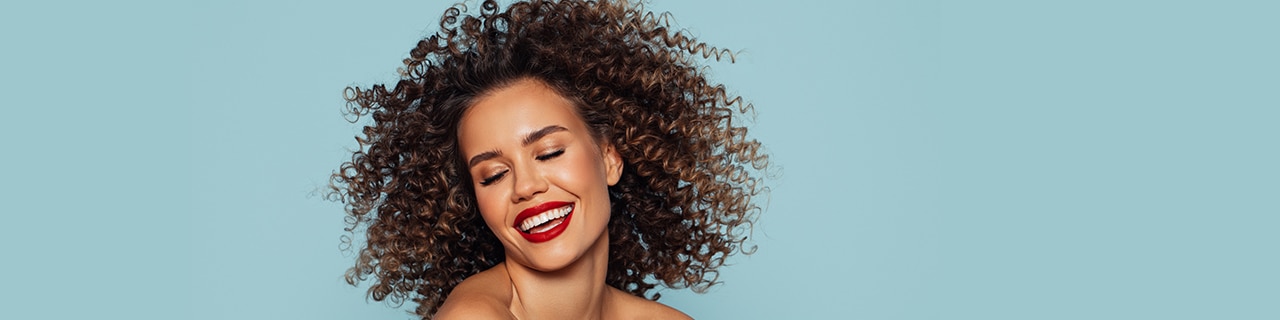mulher sorrindo feliz com os cuidados para cabelo